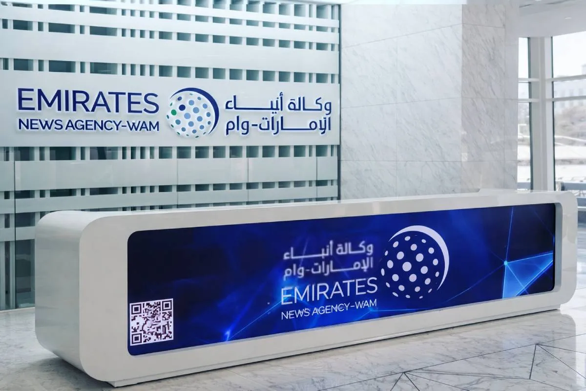 reception signage and vinyl wall branding for Emirates News Agency (WAM) executive offices in Abu Dhabi.